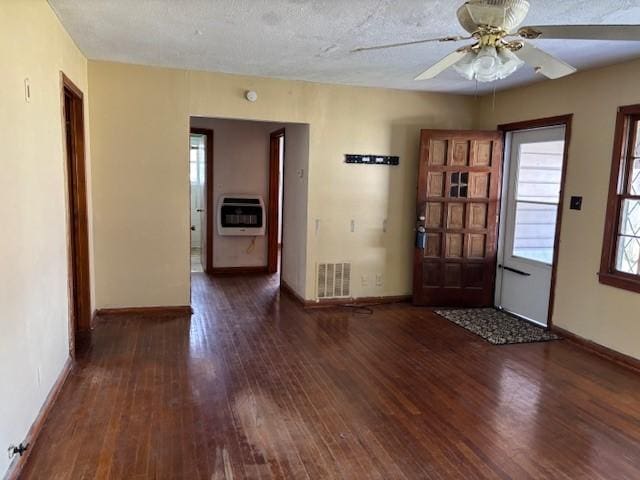 foyer entrance with baseboards, wood finished floors, visible vents, and heating unit