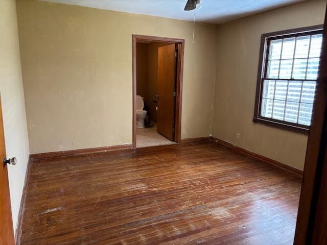 spare room featuring ceiling fan, baseboards, and wood finished floors