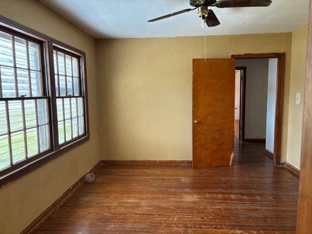 unfurnished room featuring wood finished floors, a ceiling fan, and baseboards