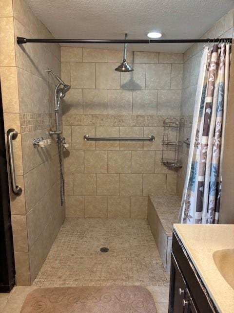 full bath with a textured ceiling, a stall shower, and vanity