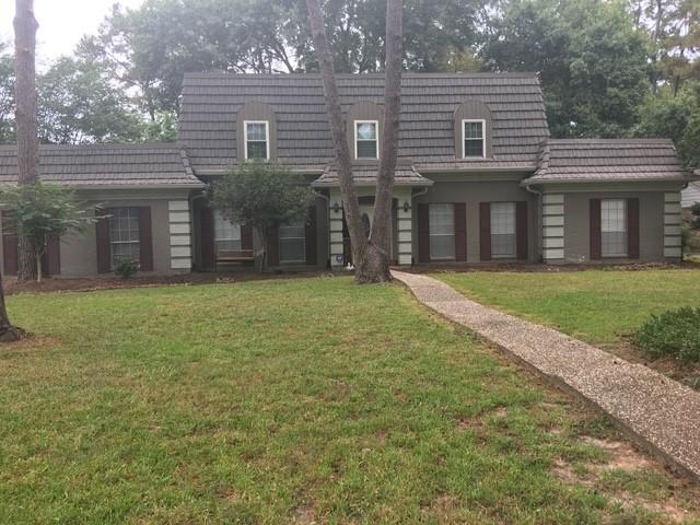 view of front of house featuring a front yard and mansard roof