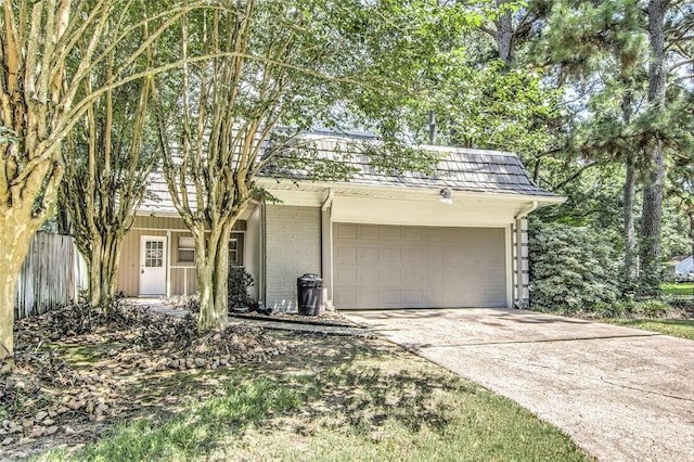 view of front of home with an attached garage, mansard roof, concrete driveway, and brick siding