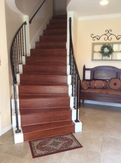 stairs with baseboards, tile patterned floors, and crown molding