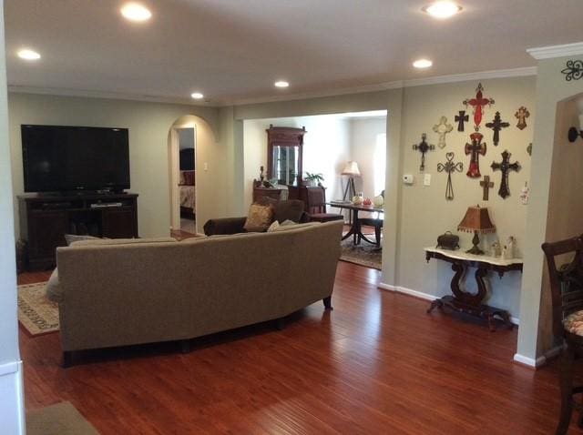 living room with recessed lighting, arched walkways, dark wood-style flooring, and ornamental molding