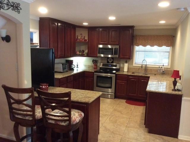 kitchen with stainless steel appliances, ornamental molding, a peninsula, and a sink