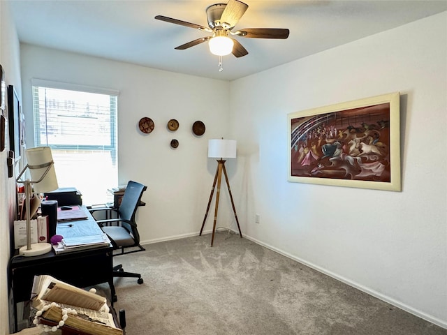 carpeted office with ceiling fan and baseboards