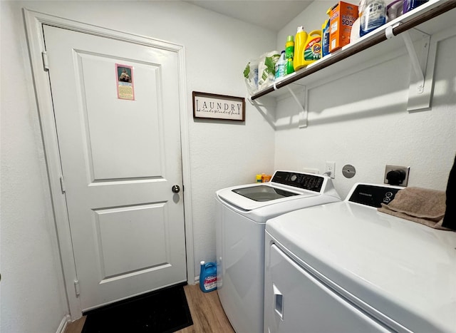 laundry room with laundry area, separate washer and dryer, and wood finished floors