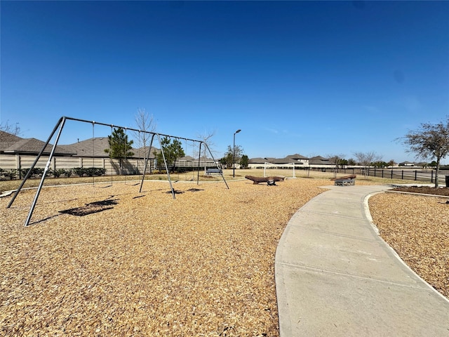 view of yard featuring playground community and fence