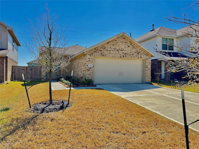 view of front of house with brick siding, concrete driveway, an attached garage, fence, and a front yard