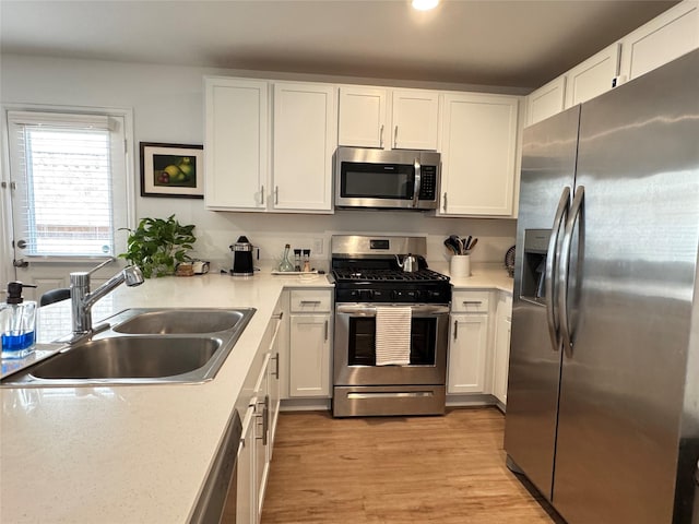 kitchen featuring white cabinetry, stainless steel appliances, and a sink