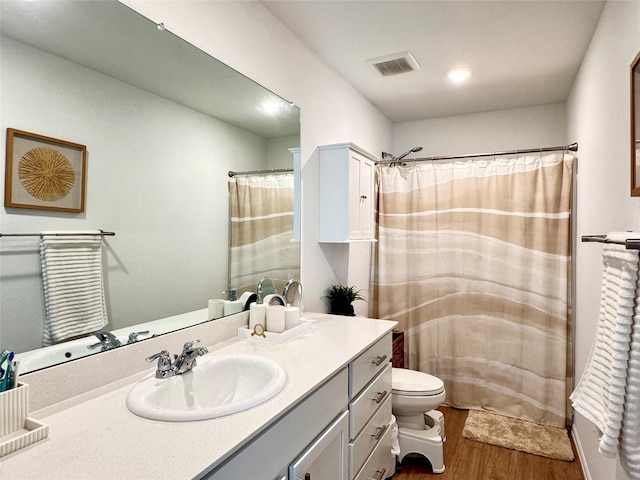 full bathroom featuring curtained shower, visible vents, toilet, vanity, and wood finished floors