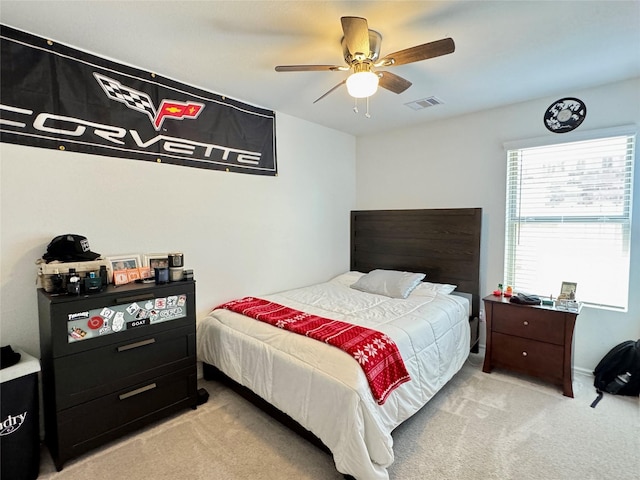 bedroom featuring light carpet, visible vents, and a ceiling fan