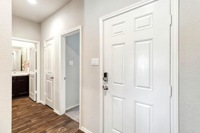 hall featuring dark wood-style floors and baseboards