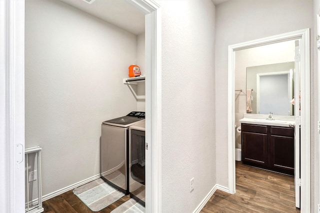 laundry area with a sink, dark wood-type flooring, washing machine and dryer, and laundry area