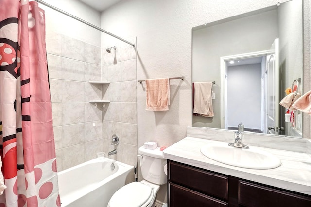 full bathroom with shower / bath combo with shower curtain, toilet, vanity, and a textured wall