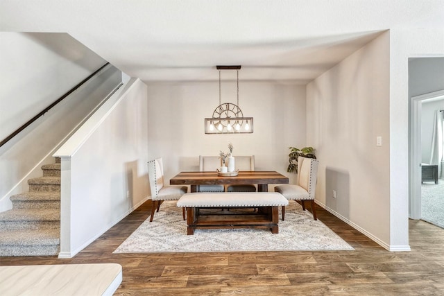 dining space featuring stairs, wood finished floors, and baseboards