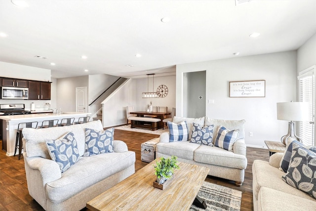 living room with recessed lighting, baseboards, dark wood-style floors, and stairs