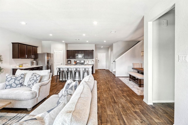 living room with dark wood finished floors, recessed lighting, and baseboards