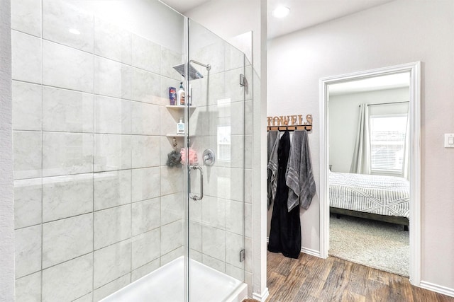 full bathroom featuring connected bathroom, baseboards, wood finished floors, and a shower stall