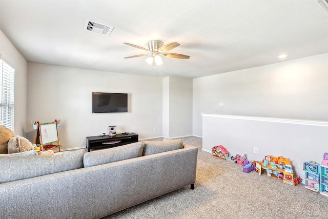 living area featuring visible vents, a ceiling fan, and carpet floors