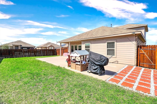 rear view of property with a fenced backyard, a lawn, a patio, and roof with shingles