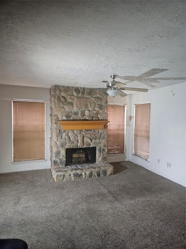 unfurnished living room with carpet floors, a stone fireplace, and a textured ceiling