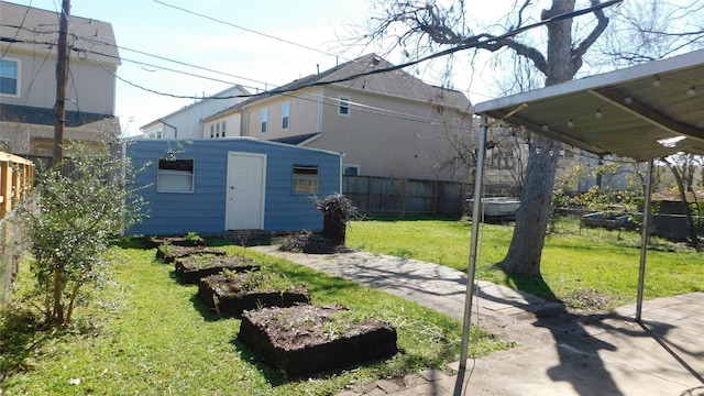 view of yard featuring an outdoor structure, a vegetable garden, and fence