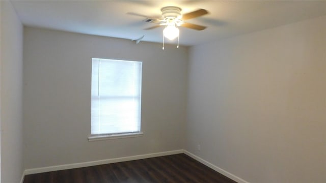 spare room featuring dark wood-style flooring, visible vents, ceiling fan, and baseboards