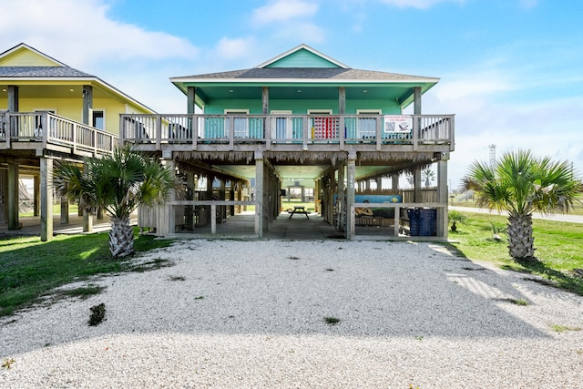 view of front facade featuring gravel driveway, a shingled roof, cooling unit, and a carport