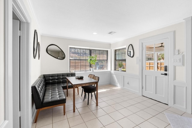 dining area featuring breakfast area, visible vents, ornamental molding, and light tile patterned flooring