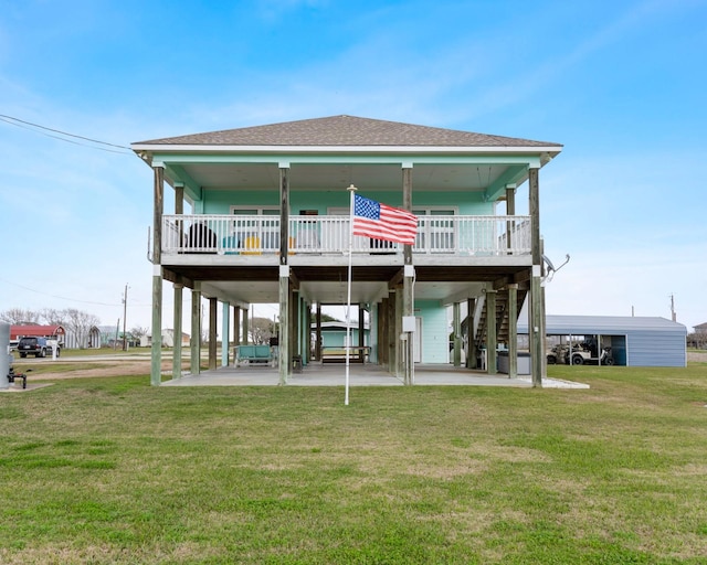 rear view of property with a yard, stairway, a porch, and roof with shingles