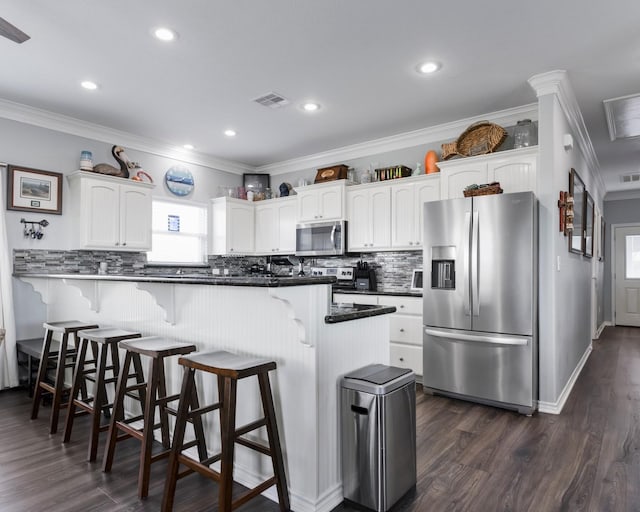 kitchen featuring appliances with stainless steel finishes, a healthy amount of sunlight, visible vents, and white cabinetry