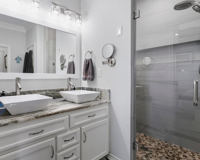 bathroom featuring ornamental molding, a stall shower, and a sink