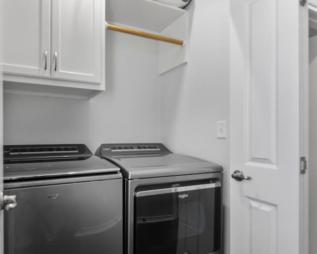 clothes washing area with cabinet space and independent washer and dryer