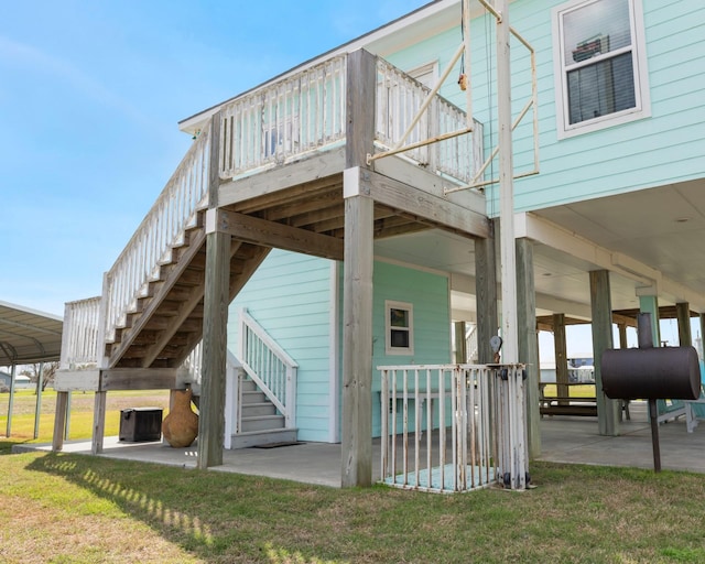 back of property with stairs, a yard, central AC, and heating fuel