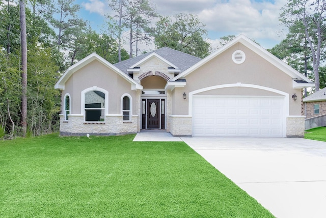 view of front of home featuring an attached garage, driveway, a front lawn, and stucco siding