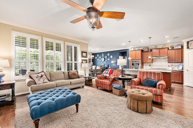 living area with recessed lighting, ornamental molding, ceiling fan, wood finished floors, and baseboards