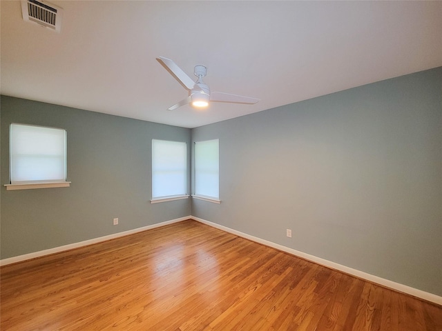 unfurnished room with light wood-type flooring, baseboards, visible vents, and a ceiling fan