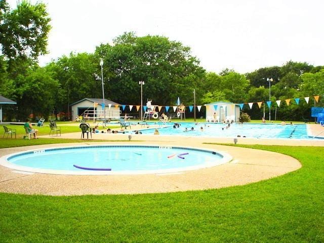 community pool featuring a lawn and an outdoor structure