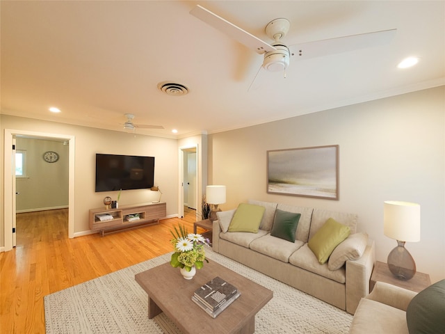 living room with crown molding, light wood finished floors, a ceiling fan, and recessed lighting