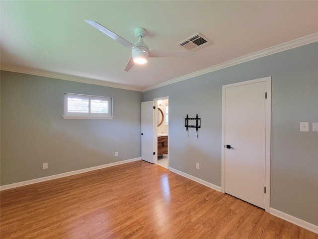 unfurnished bedroom featuring light wood-type flooring, baseboards, visible vents, and crown molding