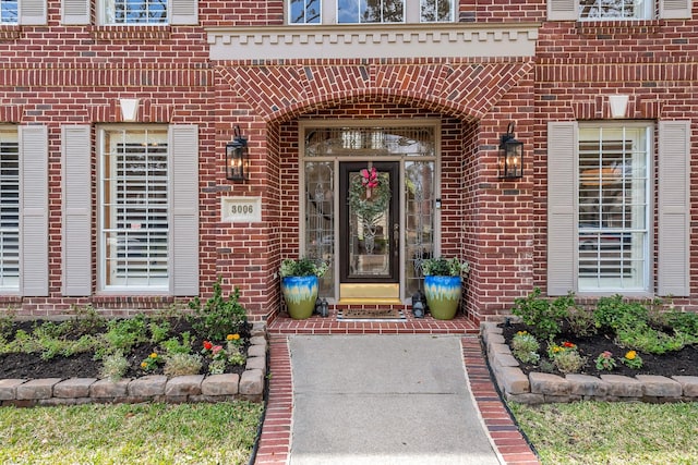 view of exterior entry with brick siding