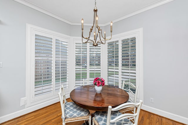 dining area with baseboards, a chandelier, wood finished floors, and ornamental molding