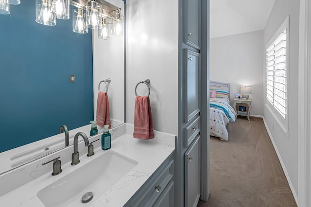 bathroom with ensuite bath, baseboards, and vanity