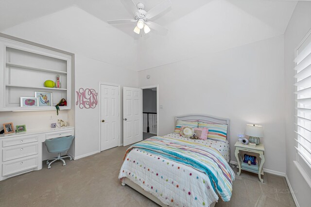 bedroom with light carpet, ceiling fan, built in study area, and baseboards