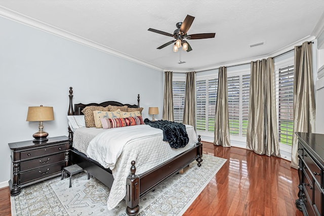 bedroom featuring visible vents, a ceiling fan, wood finished floors, crown molding, and a textured ceiling