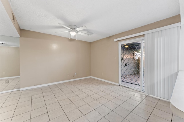 empty room featuring ceiling fan, light tile patterned floors, a textured ceiling, and baseboards