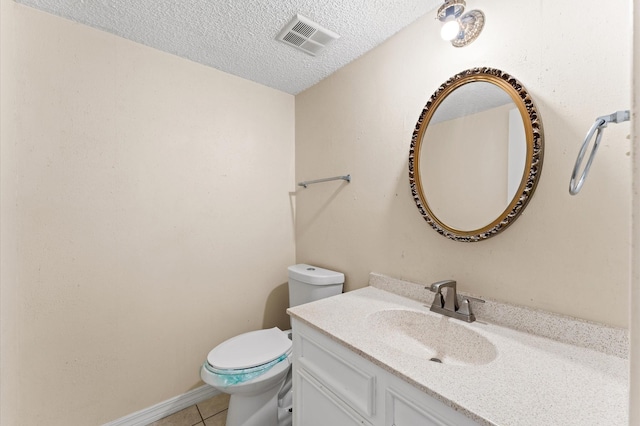 bathroom featuring visible vents, toilet, a textured ceiling, vanity, and tile patterned flooring