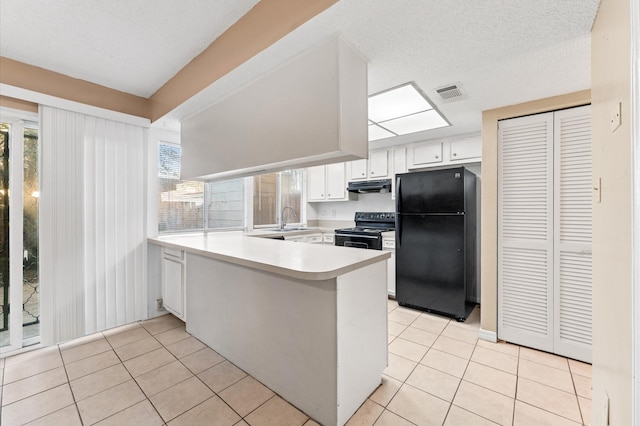 kitchen featuring light tile patterned floors, black appliances, a peninsula, and visible vents