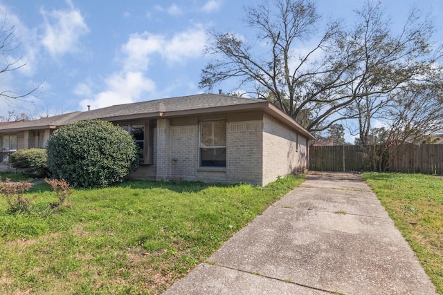 view of front of property with brick siding, a front yard, and fence